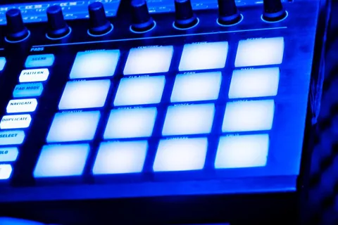 Les pads lumineux d’une boîte à rythmes dans la nuit bleue du studio